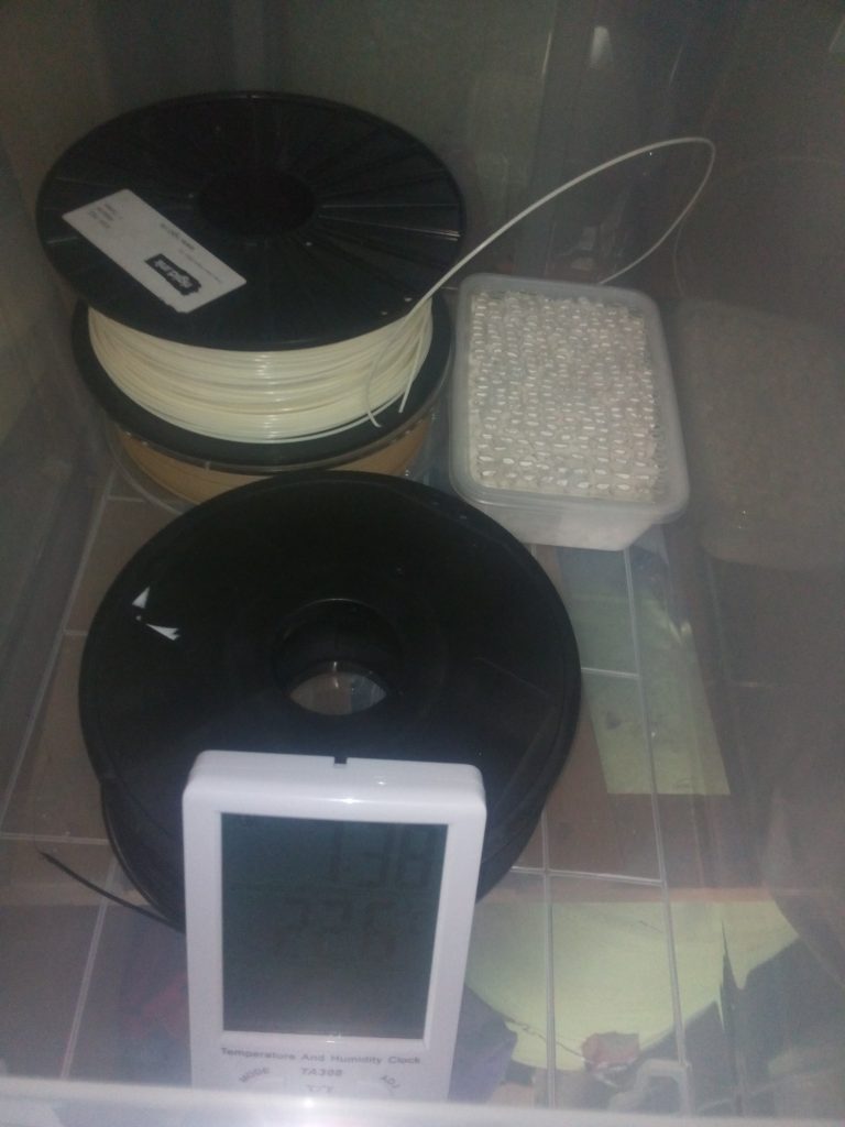 Plaster granules, hygrometer and filament spools inside the dry box