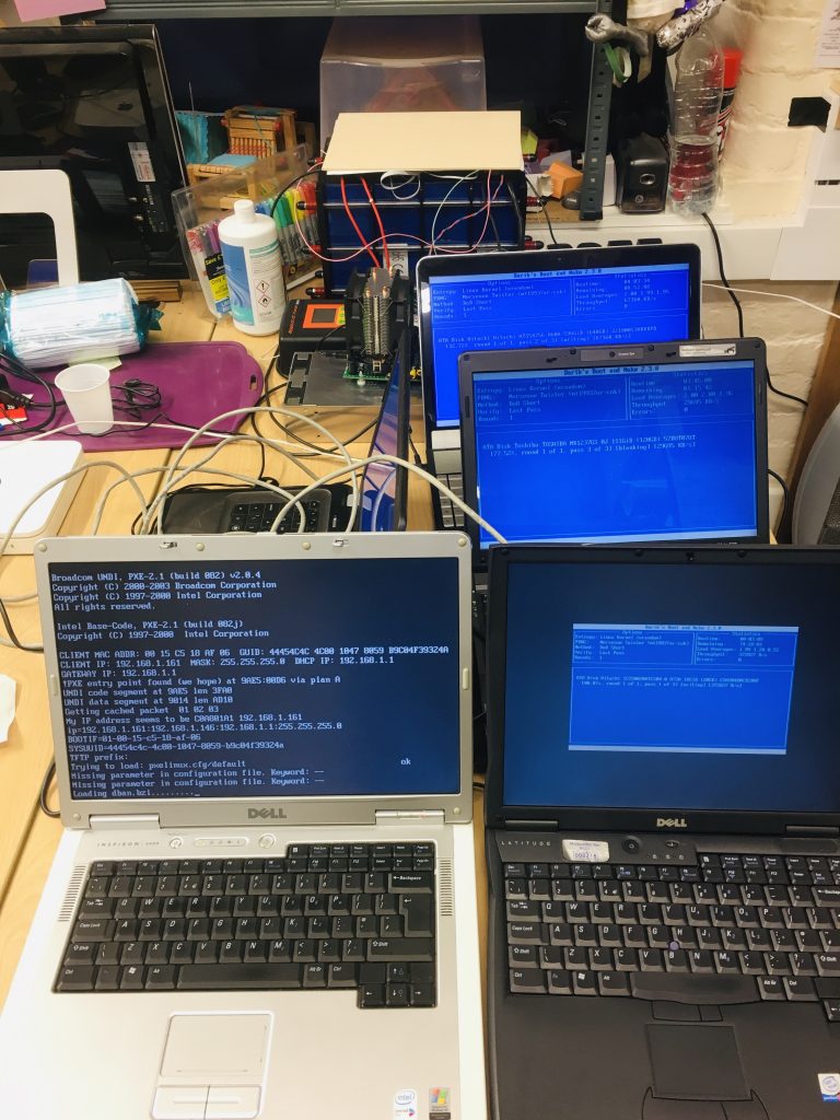 5 laptops of varying ages, one of which is in the process of booting from the network and the other 4 are wiping their disks.